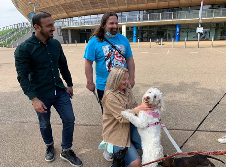 two men and a woman stroking a dog