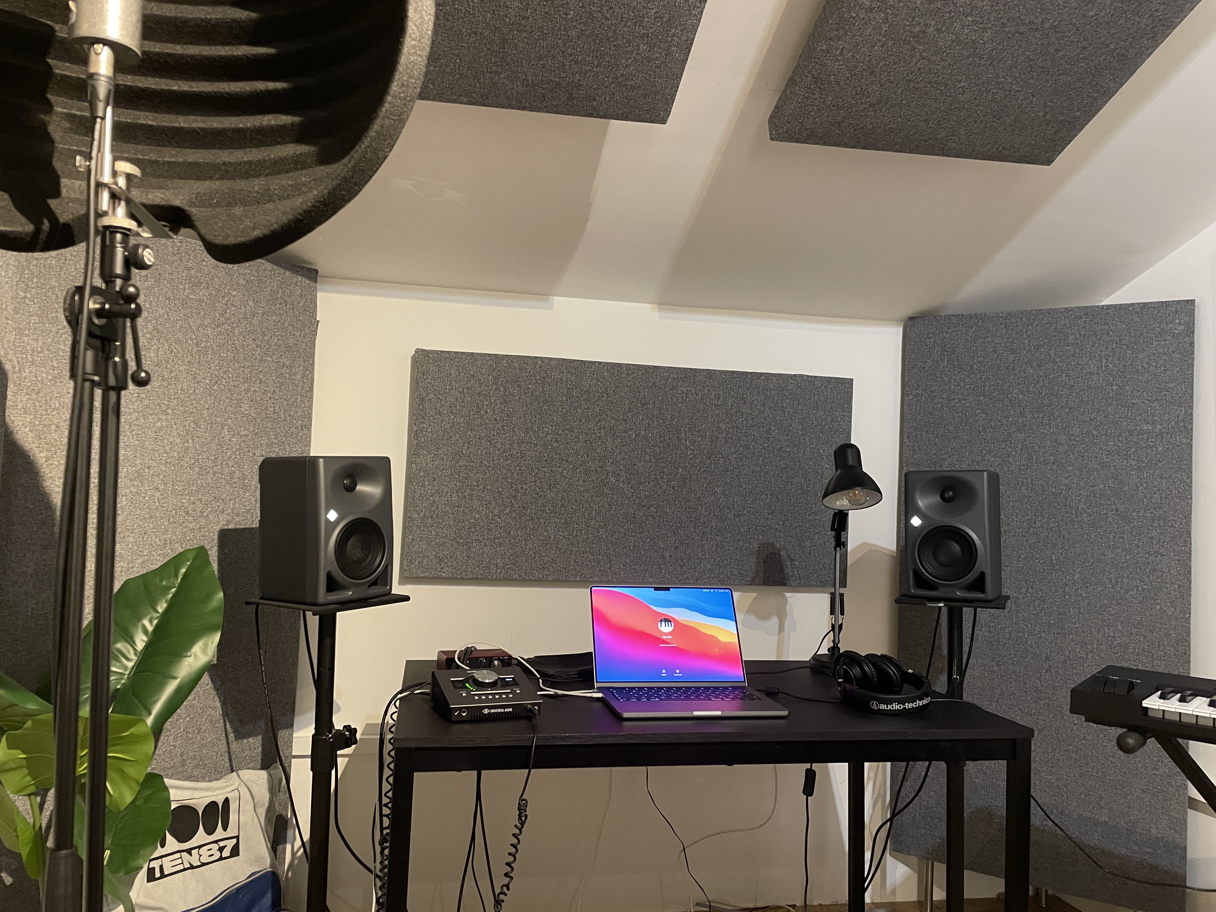 Laptop on a desk surrounded by speaker equipment. 