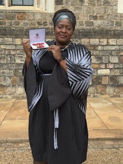 Lorraine Sunduza holding her OBE medal.