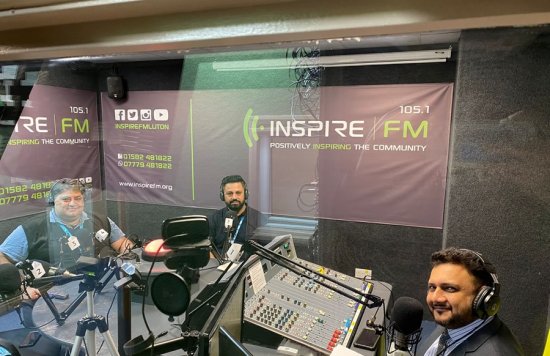 Zaz behind radio microphone with Inspire FM DJs