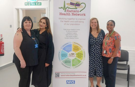 Hatters Health Primary Care Network (PCN) and ELFT staff standing next to a Hatters Health Network banner. 